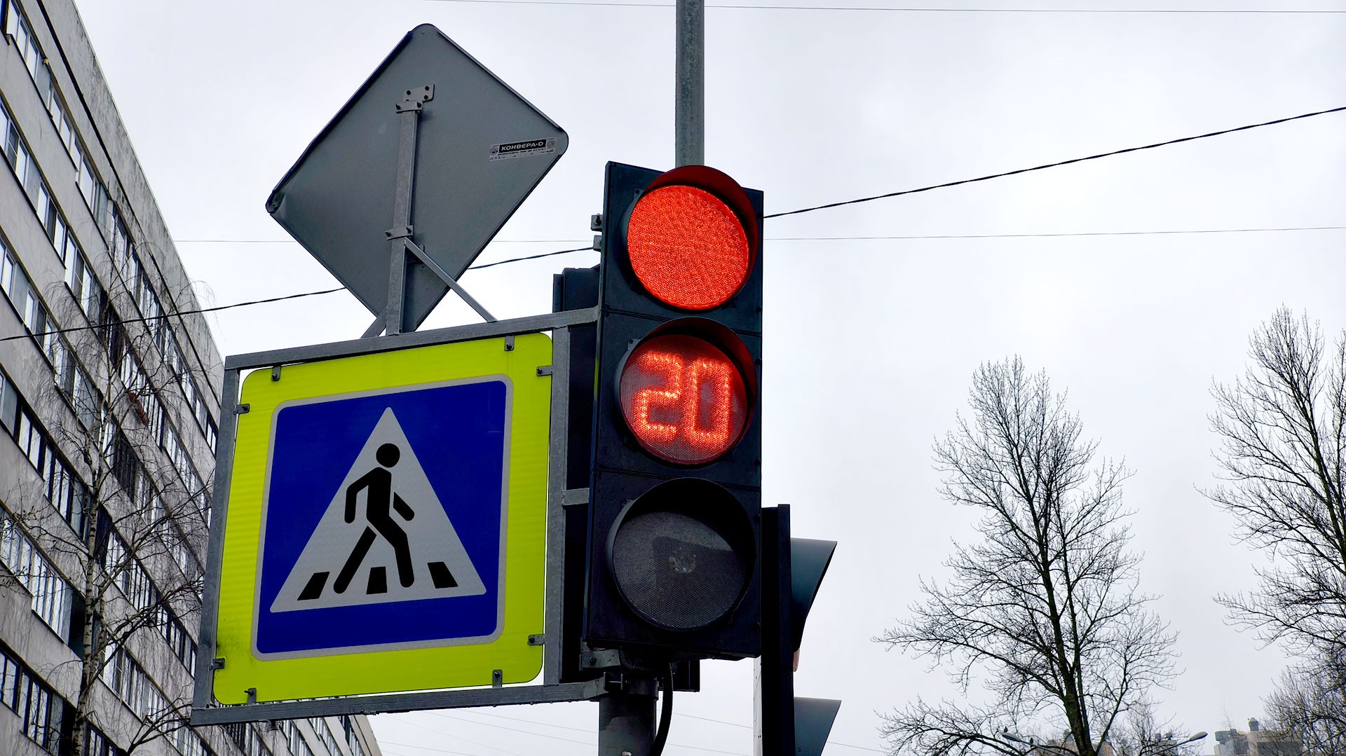 Красный свет светофора с таймером 20 секунд и пешеходным знаком на городской улице