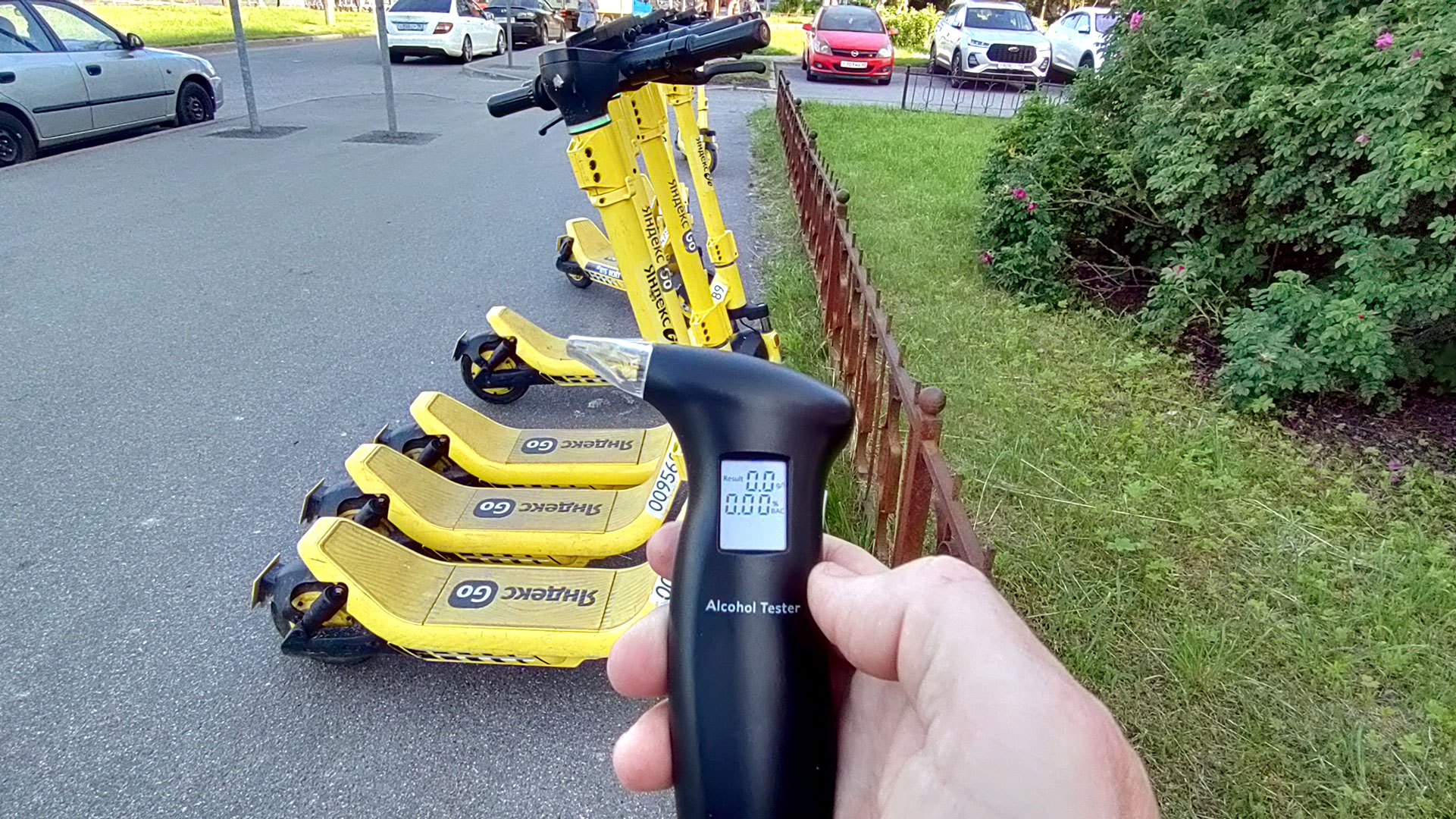 Алкотестер показывает 0.00, на заднем плане электросамокаты
